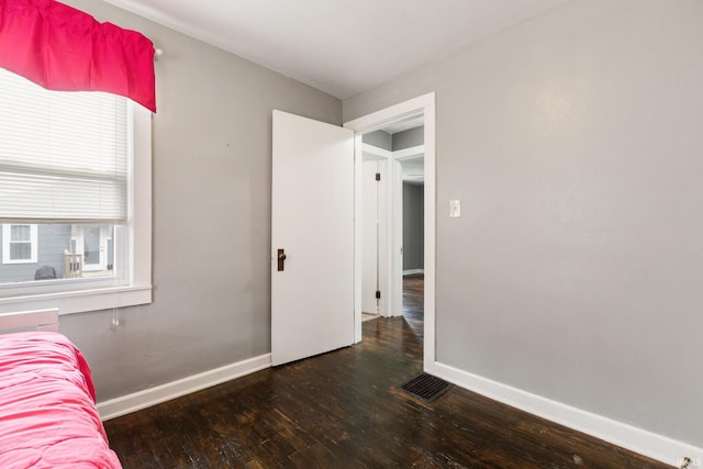 bedroom featuring hardwood / wood-style floors and baseboards