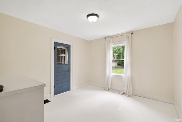 unfurnished room with baseboards