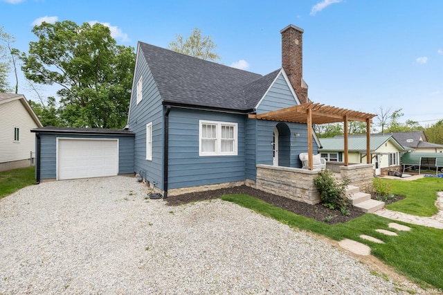 view of front facade with driveway, roof with shingles, a pergola, and a garage