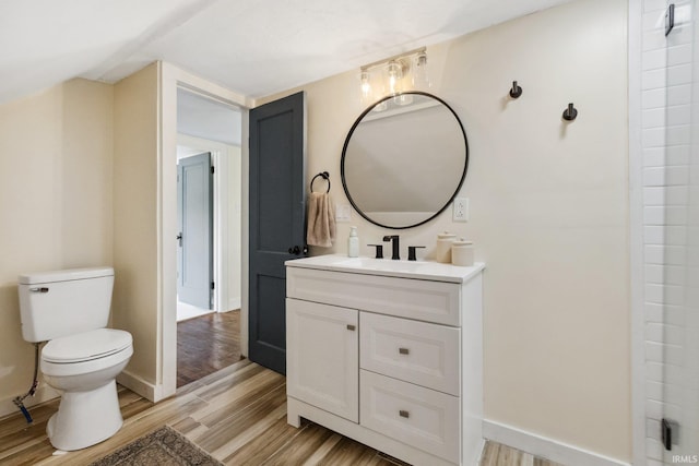 bathroom with wood finished floors, toilet, vanity, and baseboards