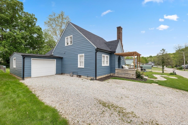 view of home's exterior featuring a chimney, driveway, a garage, a lawn, and roof with shingles