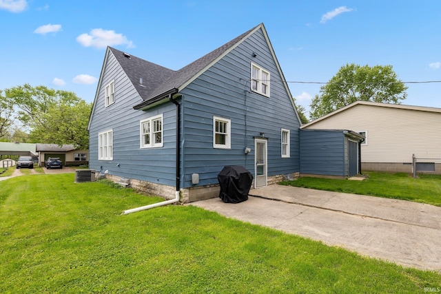 rear view of property with central AC, a lawn, a patio area, and a shingled roof