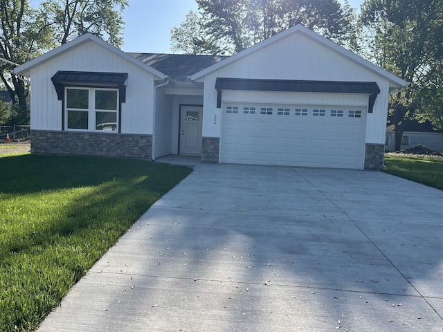 309 N Winchester St, Geneva, IN 46740 - single story home with stone siding, a garage, concrete driveway, and a front yard