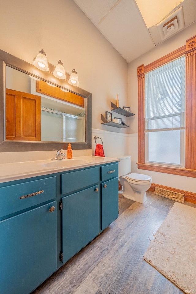 521 S Riverside Dr, Winamac, IN 46996 - full bath featuring wood finished floors, vanity, toilet, and a shower