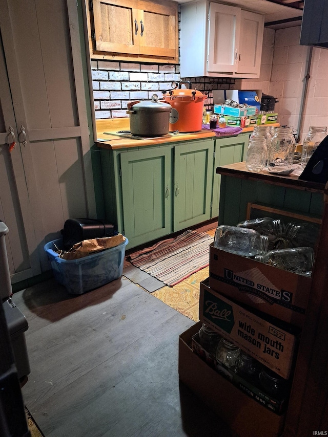 kitchen with green cabinetry and tasteful backsplash