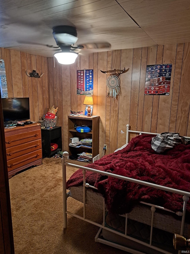 carpeted bedroom featuring wood walls