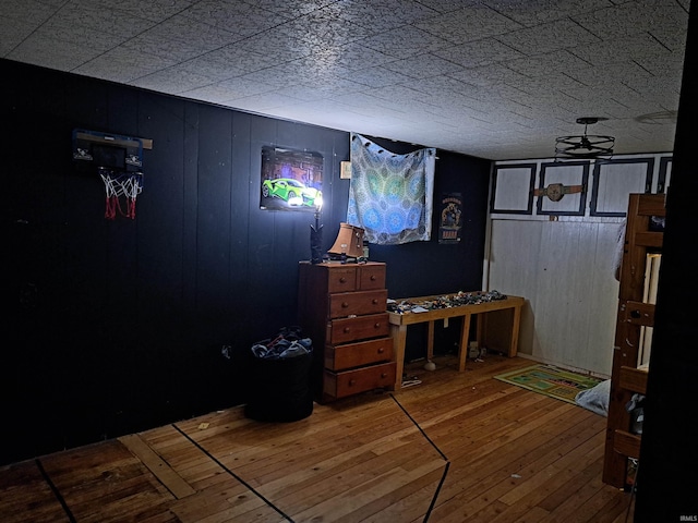 bedroom with hardwood / wood-style floors and wood walls