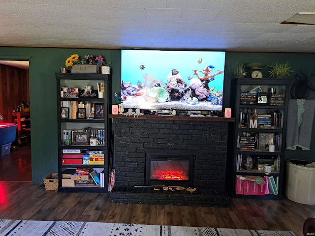living room with wood finished floors and a brick fireplace
