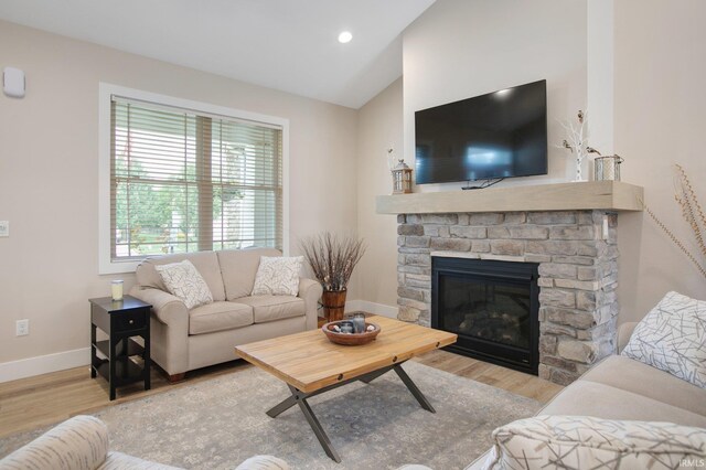 104 Lavender Ct, New Carlisle, IN 46552 - living room featuring wood finished floors, baseboards, a stone fireplace, lofted ceiling, and recessed lighting
