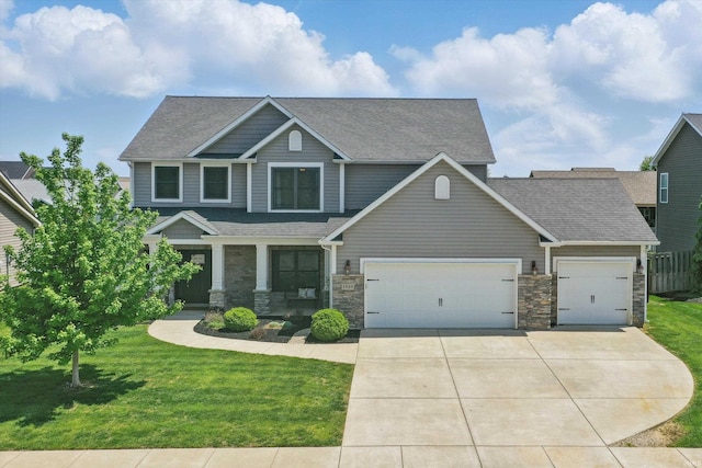 craftsman-style home featuring a garage, concrete driveway, a front yard, roof with shingles, and stone siding