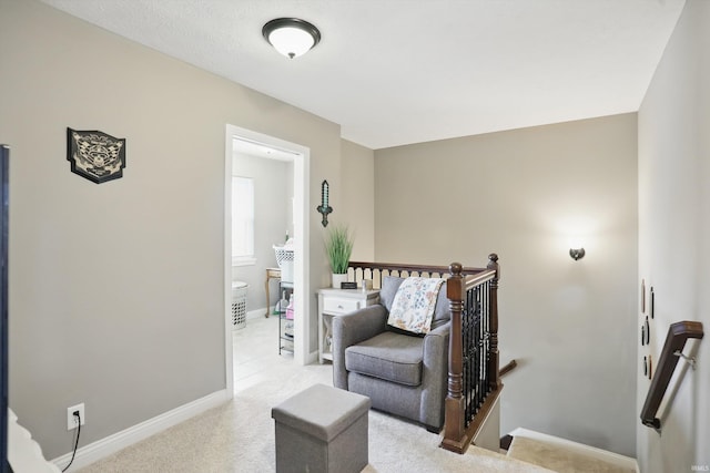 sitting room with an upstairs landing, carpet flooring, and baseboards