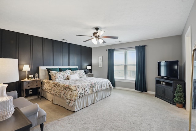 bedroom featuring light colored carpet, baseboards, and ceiling fan
