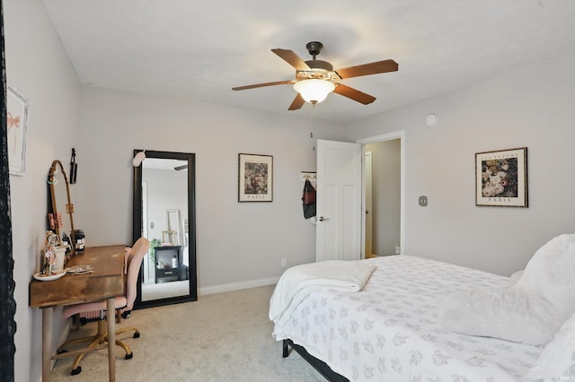 bedroom featuring a desk, light carpet, ceiling fan, and baseboards