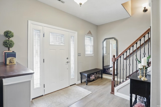 foyer with stairs, light wood-type flooring, and baseboards