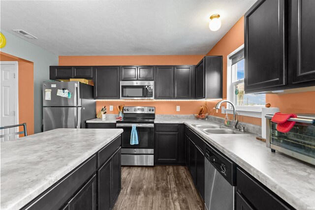 384 Ariel Dr, Kokomo, IN 46901 - kitchen featuring stainless steel appliances, a sink, dark wood-style flooring, light countertops, and dark cabinets