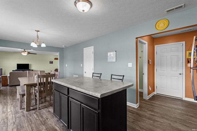 384 Ariel Dr, Kokomo, IN 46901 - kitchen featuring a ceiling fan, dark wood-type flooring, dark cabinets, a chandelier, and a kitchen island