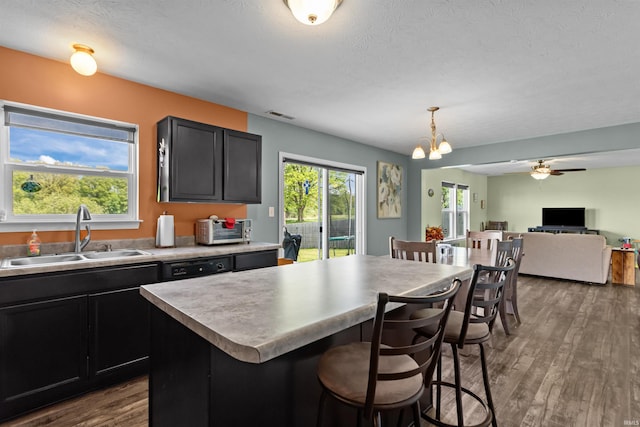 384 Ariel Dr, Kokomo, IN 46901 - kitchen with a sink, dark wood-style flooring, a breakfast bar, a chandelier, and a ceiling fan