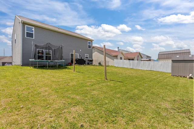 384 Ariel Dr, Kokomo, IN 46901 - back of house with a storage unit, a trampoline, and an outbuilding