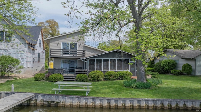 5002 E Oriole Dr, Monticello, IN 47960 - rear view of house with a yard, a balcony, a sunroom, and a deck with water view