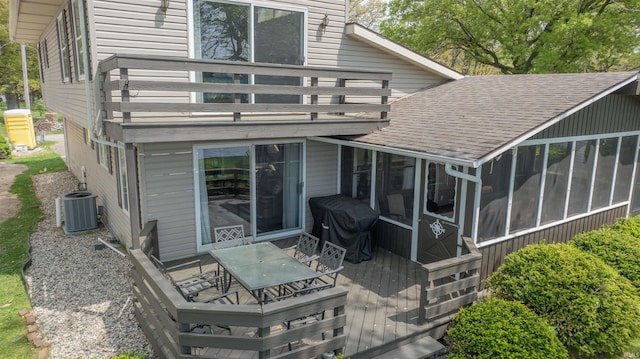 5002 E Oriole Dr, Monticello, IN 47960 - rear view of property with central AC, a sunroom, a deck, outdoor dining space, and a shingled roof