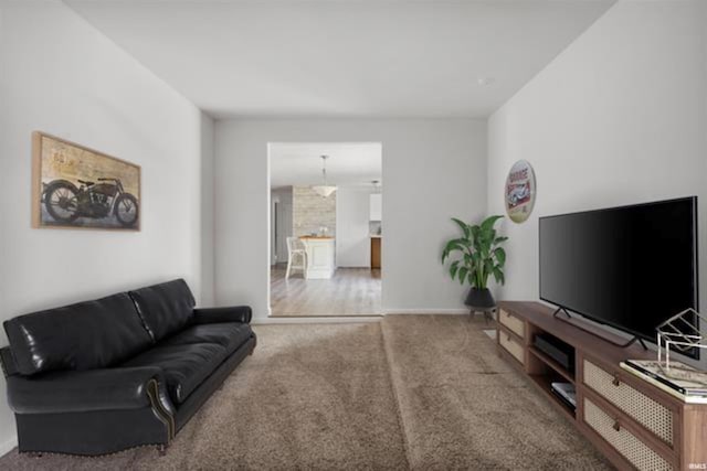 carpeted living area with baseboards