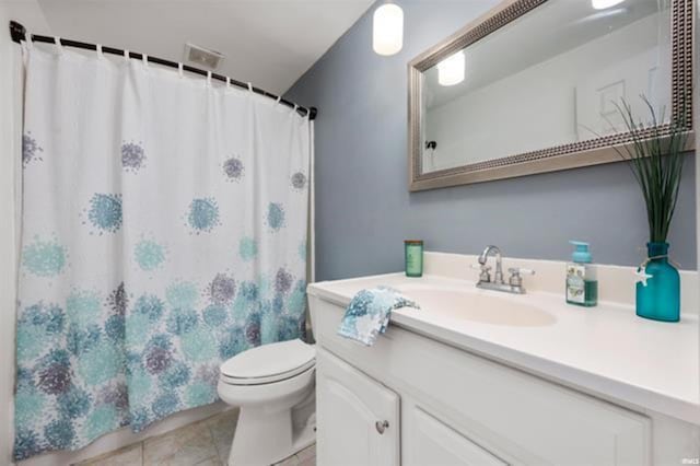 bathroom with toilet, tile patterned floors, vanity, and curtained shower