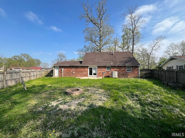 rear view of house with an outdoor fire pit and brick siding