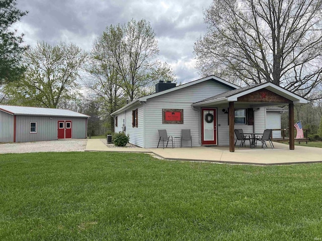 18065 Buzzard Roost Rd, Magnet, IN 47520 - back of property with a chimney, a yard, an outbuilding, and a patio
