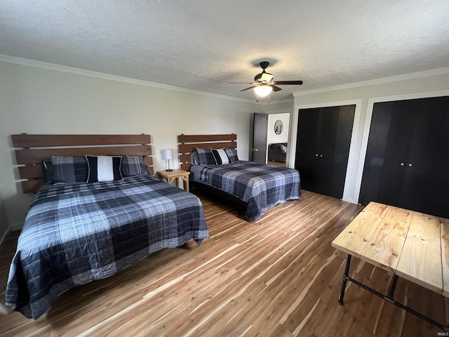 18065 Buzzard Roost Rd, Magnet, IN 47520 - bedroom with wood finished floors, ornamental molding, a textured ceiling, a ceiling fan, and multiple closets