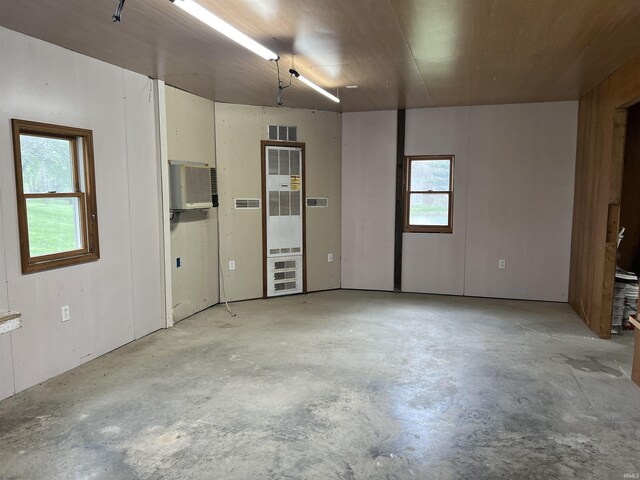 18065 Buzzard Roost Rd, Magnet, IN 47520 - unfurnished room with concrete floors, a heating unit, and a wall mounted AC