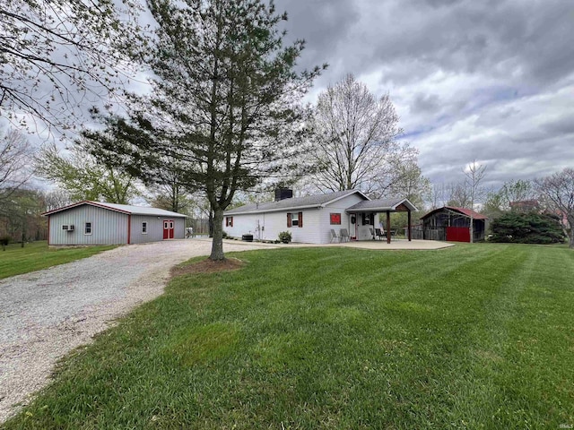 18065 Buzzard Roost Rd, Magnet, IN 47520 - ranch-style house featuring driveway, a front lawn, a detached carport, a chimney, and an outdoor structure