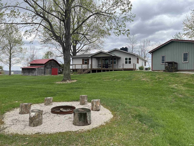 18065 Buzzard Roost Rd, Magnet, IN 47520 - view of green lawn with an outbuilding, an outdoor fire pit, and a deck