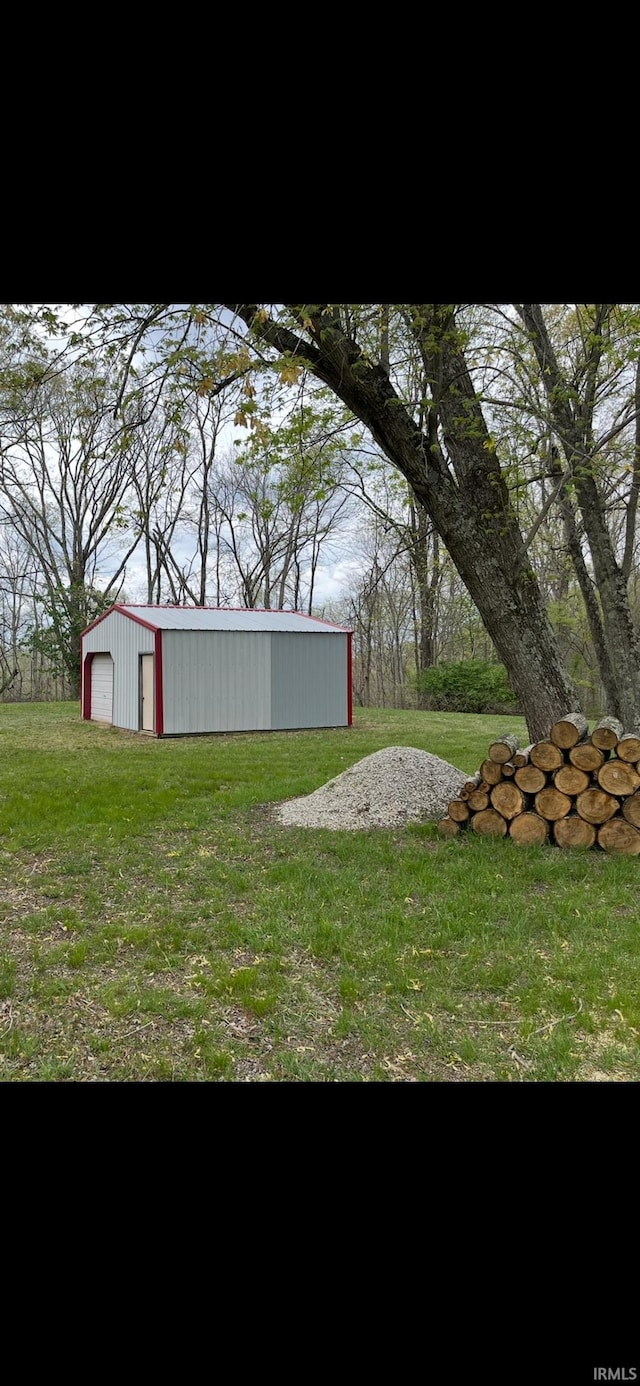 18065 Buzzard Roost Rd, Magnet, IN 47520 - view of grassy yard featuring a detached garage, an outdoor structure, and an outbuilding