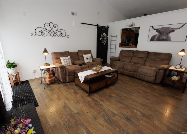 living area featuring a barn door, hardwood / wood-style floors, and high vaulted ceiling