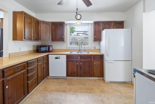 kitchen with white appliances, a sink, light countertops, and a ceiling fan