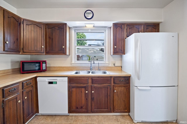 kitchen featuring white appliances, a sink, and light countertops