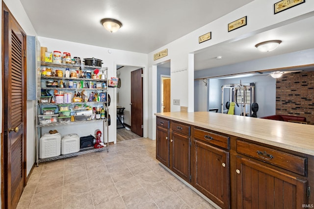 kitchen with light countertops, ceiling fan, and light tile patterned floors