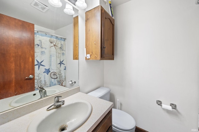 full bath with toilet, vanity, and curtained shower