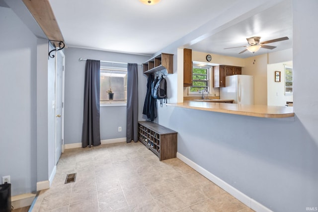 mudroom featuring a sink, a ceiling fan, and baseboards