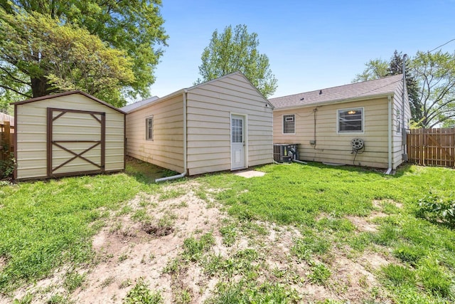 back of property featuring an outdoor structure, cooling unit, and a storage unit