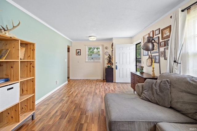 living room featuring wood finished floors, crown molding, and baseboards