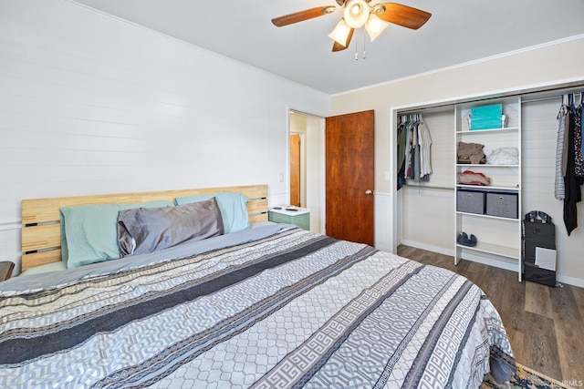 bedroom with wood finished floors, a closet, ornamental molding, a ceiling fan, and baseboards