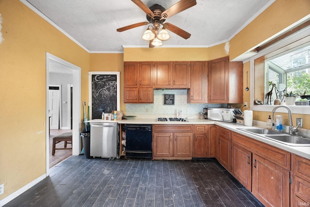 kitchen with a sink, brown cabinets, a textured ceiling, light countertops, and ornamental molding