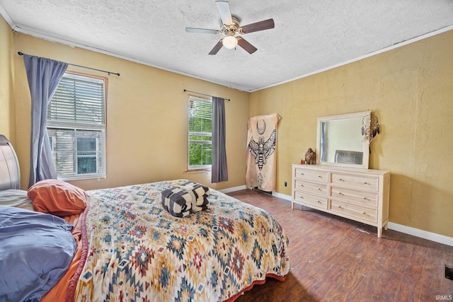 bedroom featuring a textured ceiling, wood finished floors, crown molding, baseboards, and ceiling fan