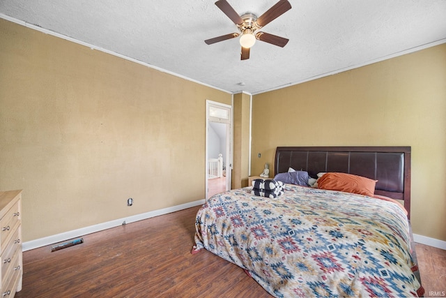 bedroom with wood finished floors, a textured ceiling, crown molding, baseboards, and ceiling fan
