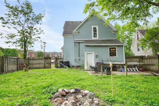 rear view of property featuring a shingled roof and a patio area