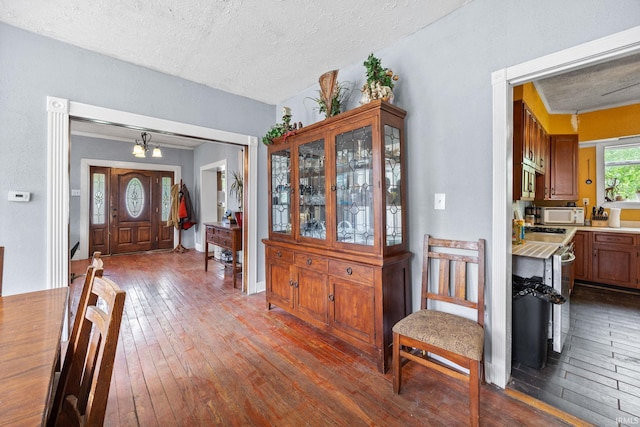 entrance foyer featuring dark wood finished floors, a textured ceiling, and a chandelier