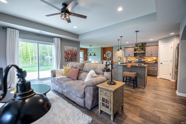 13865 Escondida Cv, Fort Wayne, IN 46845 - living room with ceiling fan, dark wood-style flooring, recessed lighting, and a tray ceiling