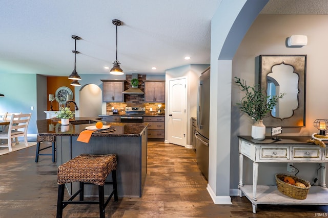 13865 Escondida Cv, Fort Wayne, IN 46845 - kitchen with wall chimney exhaust hood, a sink, stainless steel appliances, a breakfast bar area, and tasteful backsplash