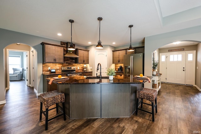 13865 Escondida Cv, Fort Wayne, IN 46845 - kitchen featuring appliances with stainless steel finishes, arched walkways, a sink, a kitchen breakfast bar, and recessed lighting